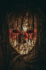 Demon girl with red eyes and cracked skin close-up portrait