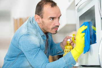 man cleans oven