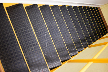 Yellow metal staircase with rubber treads and railings.
