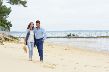 happy young couple walking on the beach