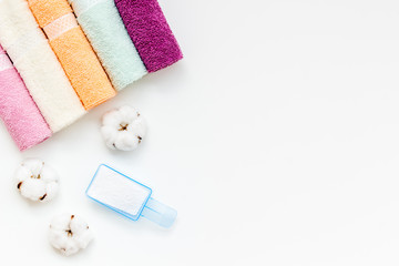 preparing for laundry with washing powder and towels on white background top view copy space