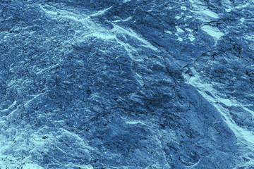 Vintage blue background. Rough painted wall of sapphire color. Imperfect plane of blue colored. Uneven old decorative toned backdrop of cyan tint. Texture of sapphirine hue. Ornamental stony surface.