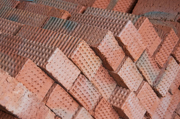 The wall is made of bricks. Brickwork in the construction of a new building. The use of a classic building material.