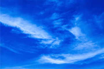 Dramatic vivid blue sky with puffy white clouds in bright clear sunny day