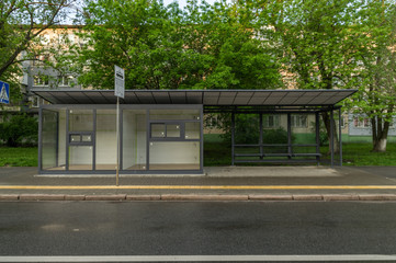 Bus stop with glass windows. Stop by the road.
