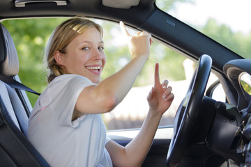 Obraz na płótnie Canvas dancing young woman driving car