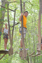 Obraz premium couple on a rope climbing in the adventure park
