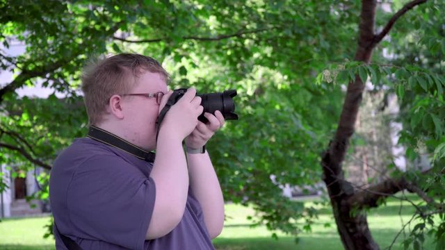 Young man takes pictures in the park