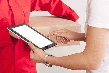 Image of a happy young delivery man in red cap standing with parcel post box isolated over white background.