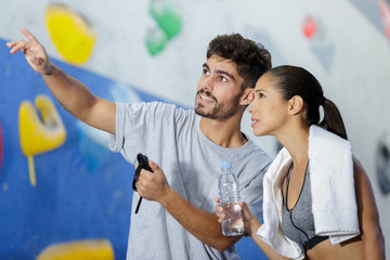 man and woman looking up at indoor climbing wall