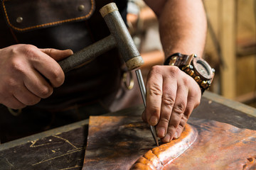 a blacksmith makes a piece of bronze - obrazy, fototapety, plakaty
