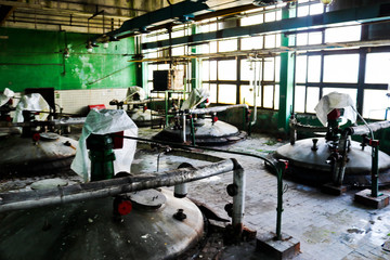Large metal iron chemical tank vessels for mixing stainless steel products, equipment, pipe heat exchangers at an industrial petrochemical refinery plant workshop