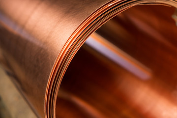 copper sheet is twisted into a large roll - obrazy, fototapety, plakaty