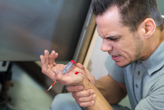handyman having screwdriver accident