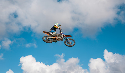 A picture of a biker making a stunt and jumps in the air