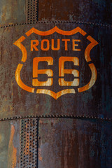 A rusty water tank with a Route 66 Marker painted on the side.