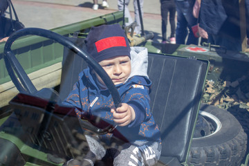 Little boy in a cap at the wheel of a car