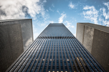 Upward view of a NYC skyscraper of glass and steel.