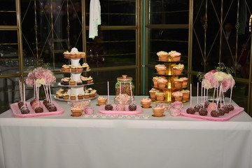Mesa adornada con cupcakes, duldes, golosinas en fista de 15 años y boda