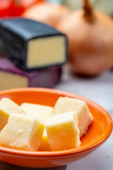 Mini black and dark red waxed cheddar cheeses with strong flavor made from West Country milk and and age-old methods with onion and garlic in England