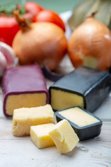 Mini black and dark red waxed cheddar cheeses with strong flavor made from West Country milk and and age-old methods with onion and garlic in England