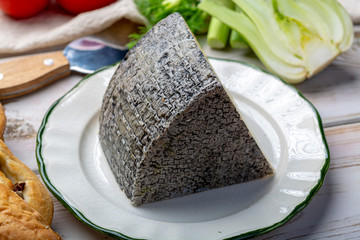 Italian cheese, piece of mature Tuscan Pecorino sheep cheese served with olive bread and tomatoes
