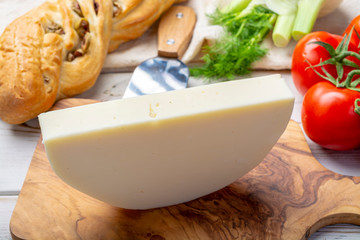 Italian cheese, Provolone dolce cow cheese from Cremona served with olive bread and tomatoes