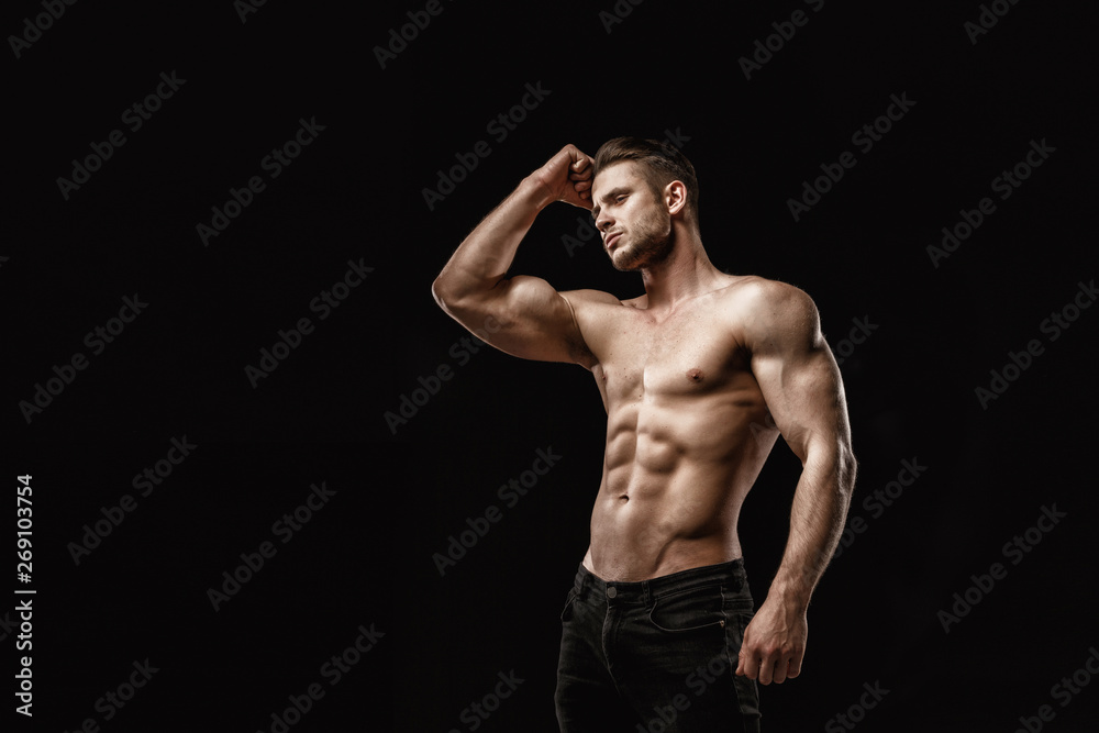 Poster muscular model young man on dark background. fashion portrait of strong brutal guy with trendy hairs