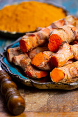 Fresh turmeric or curcuma root and dried powder, wildly used in Asia and India as spice, food ingredient and for medicinal purposes.
