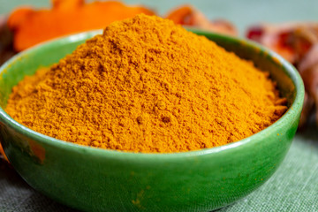 Fresh turmeric or curcuma root and dried powder, wildly used in Asia and India as spice, food ingredient and for medicinal purposes.