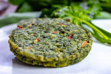 Healthy vegetarian or vegan food, uncooked green spinach burgers, ingredient for hamburgers