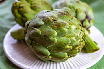 Obraz premium Heads of fresh uncooked artichoke flowers close up