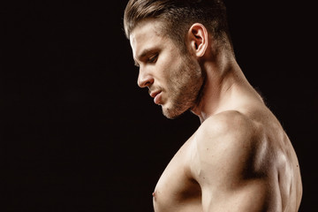 Muscular sexy model sports young man on a dark background. Portrait of sporty healthy strong brutal...