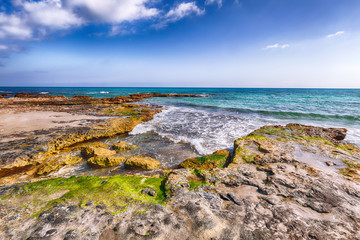 Picturesque seascape with white rocky cliffs, sea bay, islets and faraglioni near by Conca Specchiulla Beach