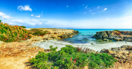 Picturesque seascape with white rocky cliffs, sea bay, islets and faraglioni near by Conca Specchiulla Beach