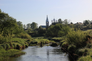 Fototapeta na wymiar View on old church from riverside in summer sunny day