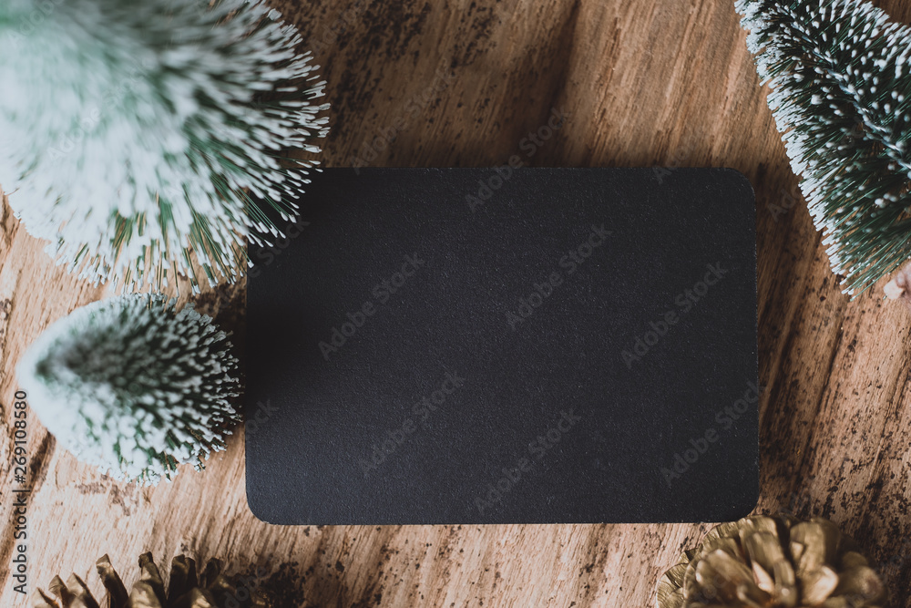 Poster top view of blank blackboard with xmas tree and gold pine cone on grunge wood table .winter holiday 