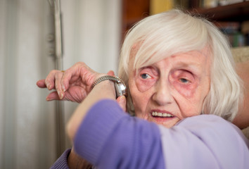 Blind,elderly woman listening to her talking wrist watch,England,U.K.