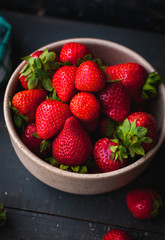 Close-up of fresh strawberries in a bowl on wooden background