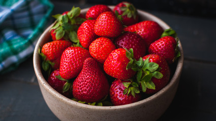 Close-up of fresh strawberries in a bowl on wooden background
