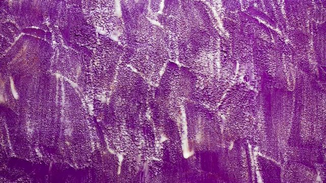 N.W. England, UK. February 2019. DIY home decorating, timelapse of paint stripping fluid causing surface bubbling as it acts on old purple gloss paint on a wood surface, prior to paint removal.