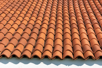 Red corrugated tile element of the roof at the house and white wall. Shingles roofing surface tiles overlay pattern and texture