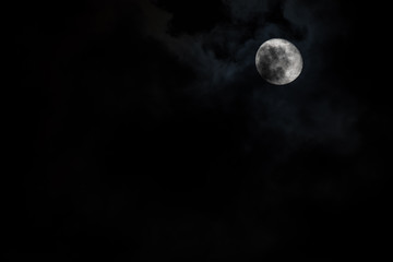 Fototapeta na wymiar Moon with light cloud cover in the sky