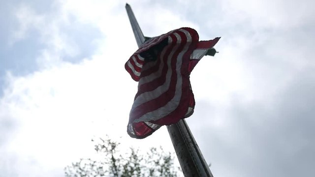 Cinematic flag raised half way up with sun background
