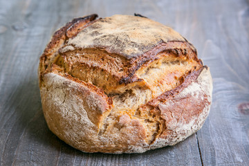 Loaf (or miche) of French sourdough, called as well as Pain de campagne, on display on a wooden table. 