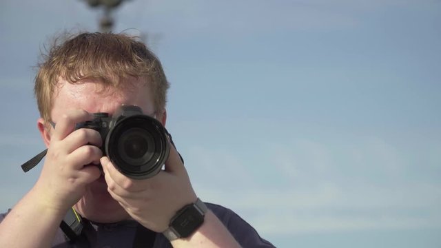 Young man takes pictures in the park