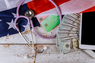 Stethoscope and tablet on credit card us dollar bill american health care