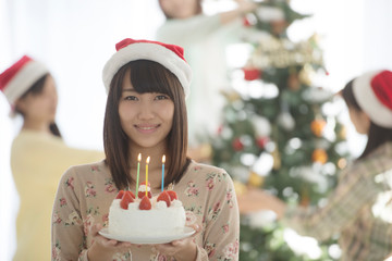 ケーキを持ち微笑む女性