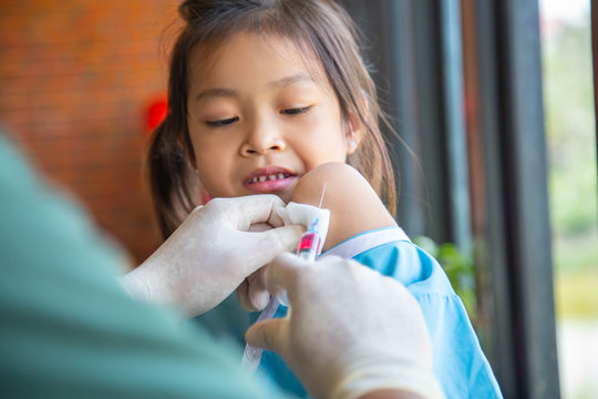 Doctor injection immunization Asian cute girl patient in hospital health care vaccine prevention cold examination disease concept