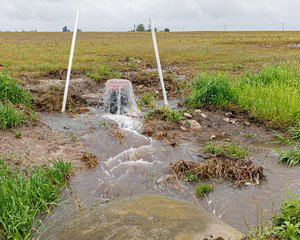 Farm field drainage system with water overflowing from heavy rains and storms in Central Illinois